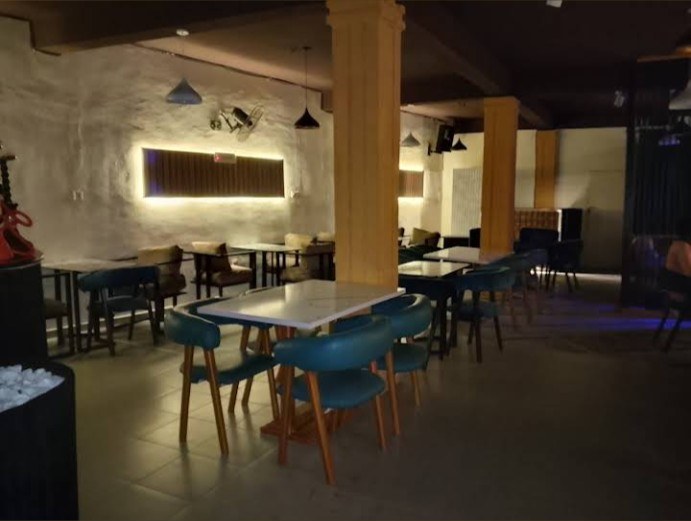 Dining room with blue chairs, tables and warm wall lighting