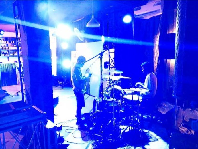 Musicians performing on a stage under blue lighting